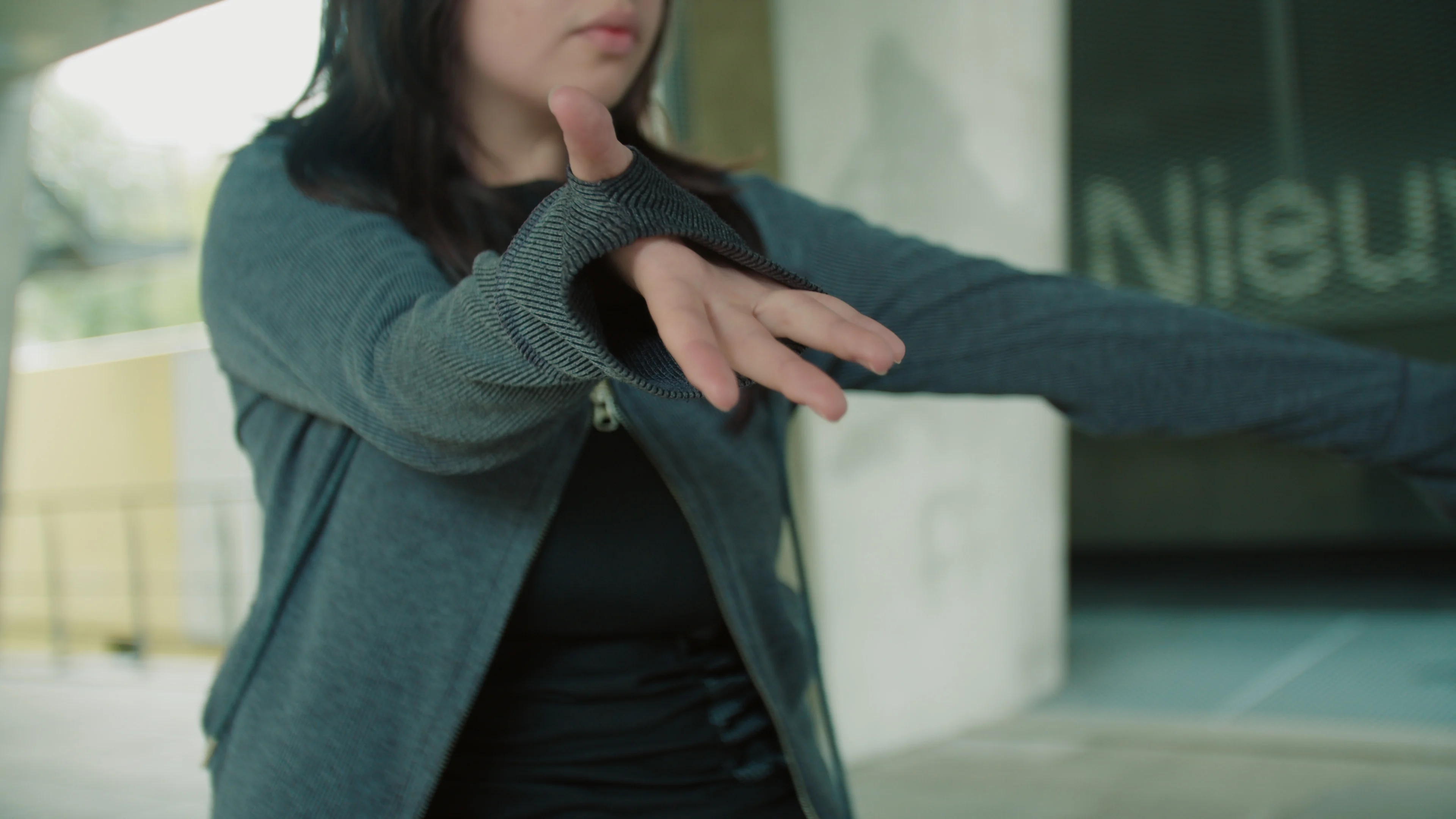 A dancer moves through a bright city walkway.