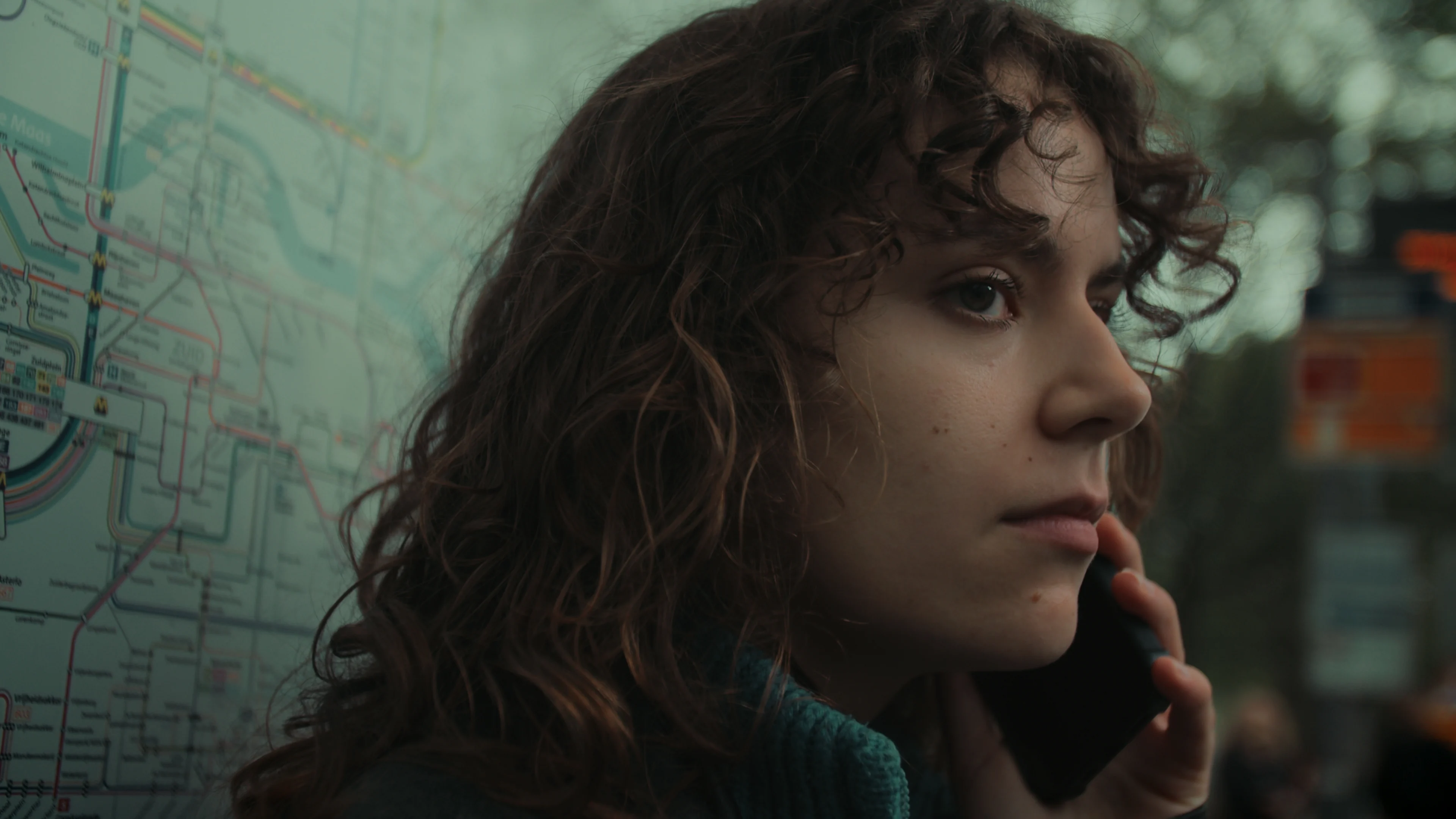 A close portrait of a woman in a quiet outdoor moment.