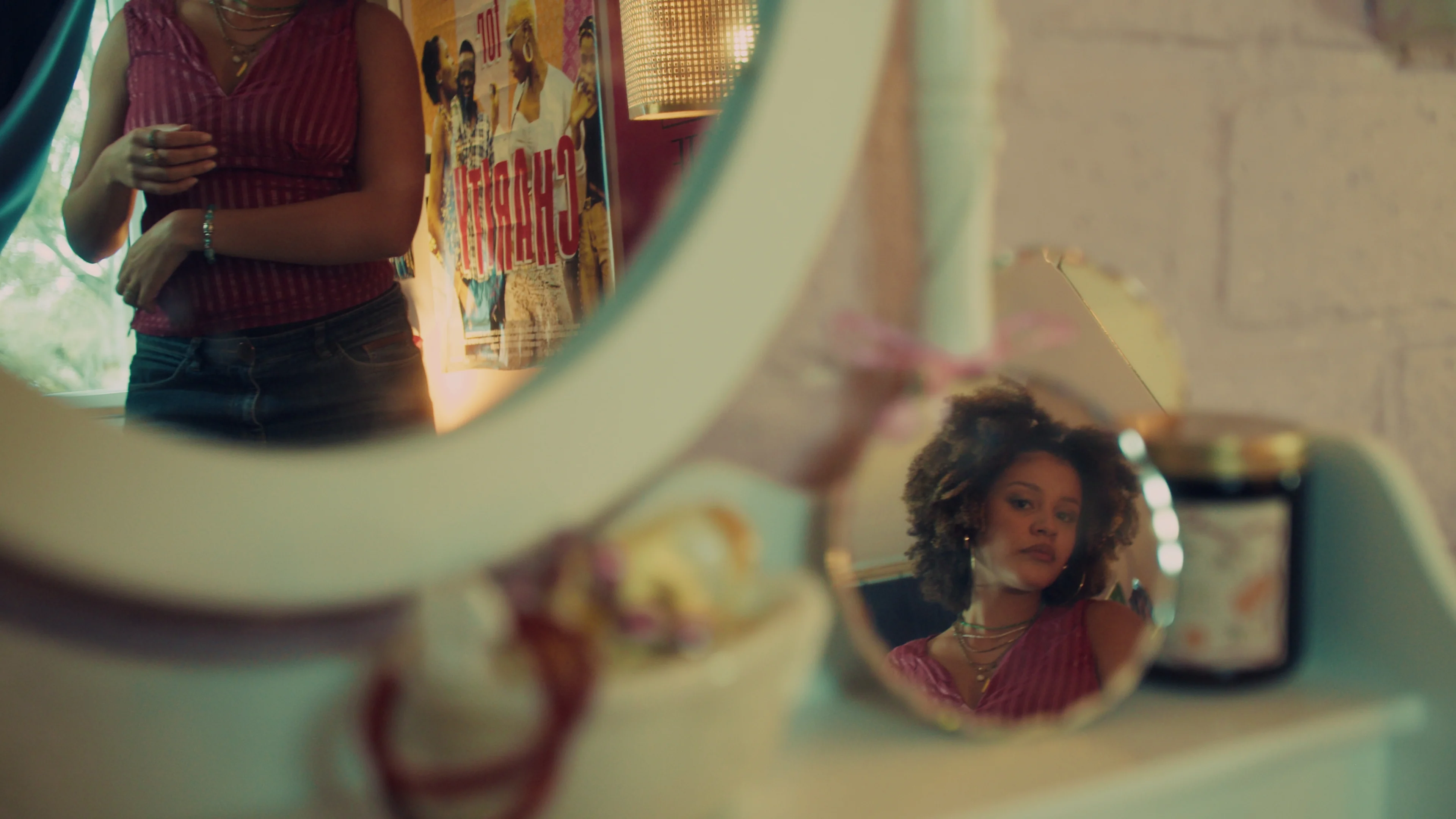 A woman reflected in a handheld mirror.