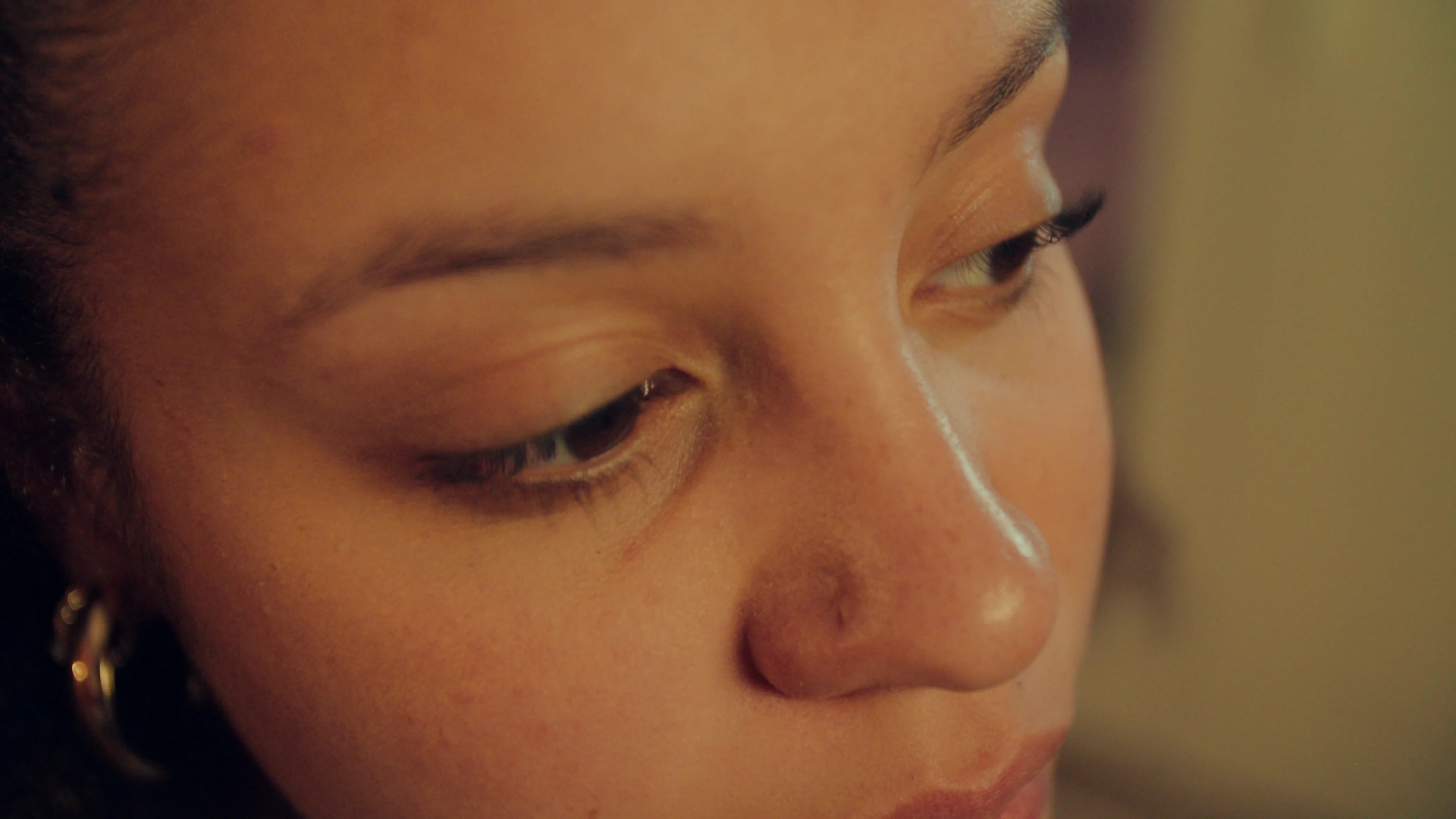 A close detail of a woman's face in warm light.